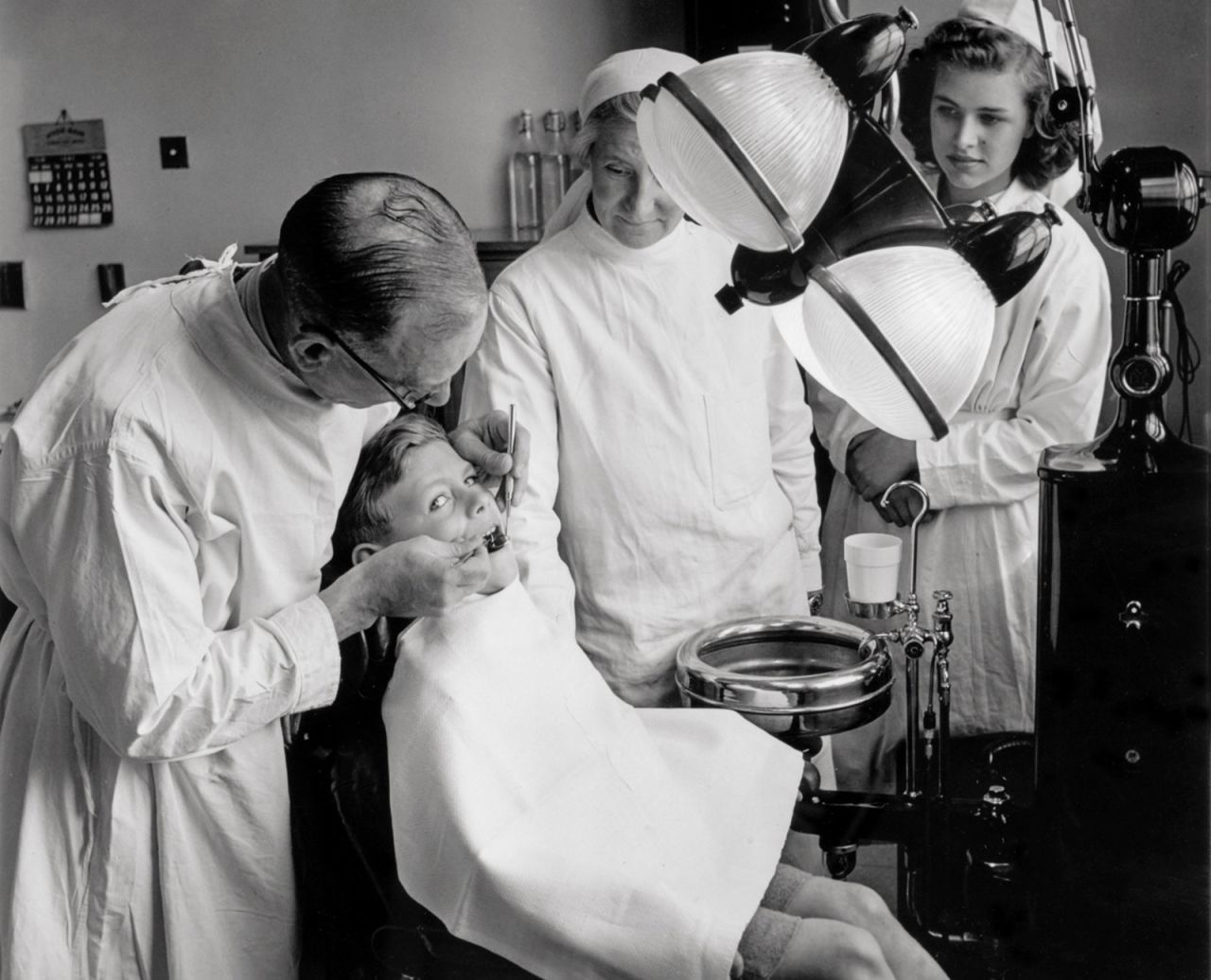 A dentist with his young patient at a health centre surgery in Bristol shortly after the NHS was established in July 1948.