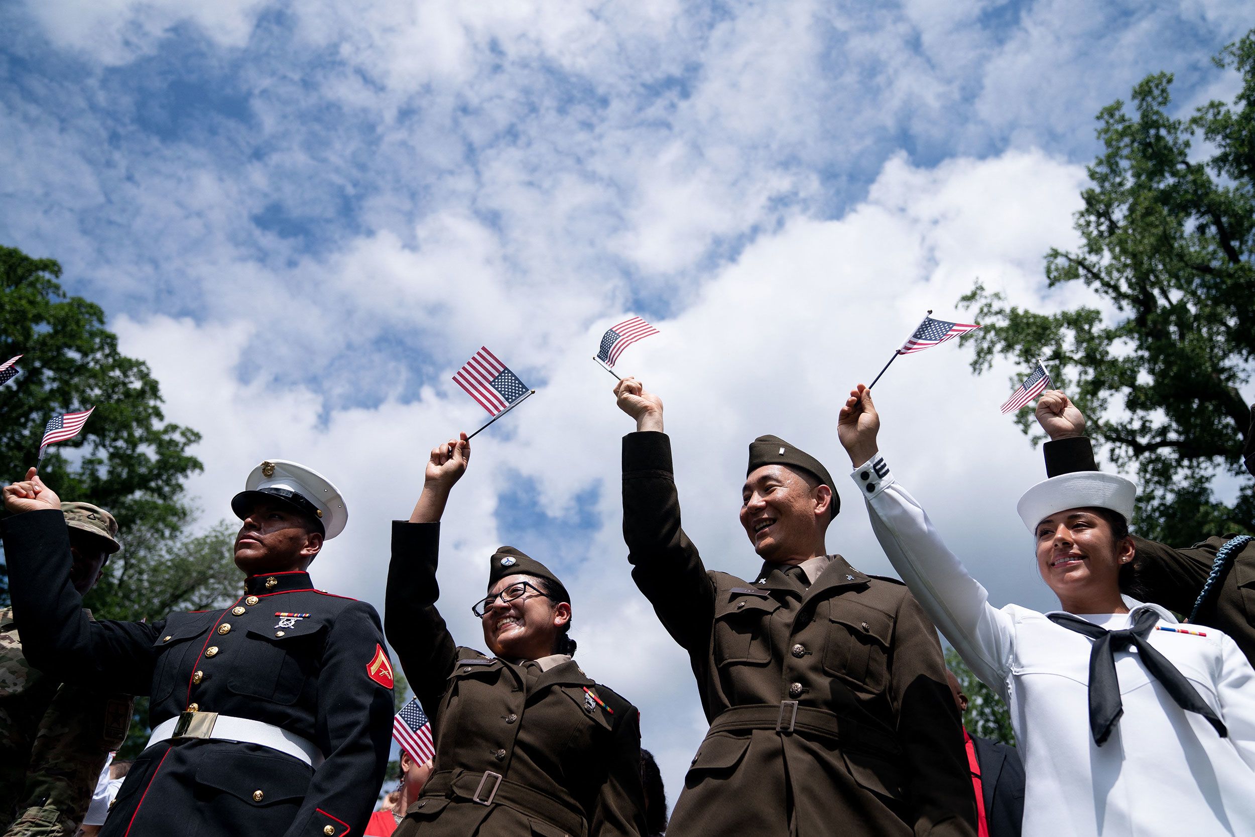 New US citizens wave flags after being sworn in at a naturalization ceremony in Mount Vernon, Virginia, on Tuesday.