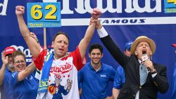 NEW YORK, NEW YORK - JULY 04: Defending champion Joey Chestnut cheers after finishing in first place in the 2023 Nathan's Famous Fourth of July International Hot Dog Eating Contest on July 4, 2023 at Coney Island in the Brooklyn borough of New York City. Chestnut won after eating 61 hot dogs. The annual contest, which began in 1972, draws thousands of spectators to Nathan's Famous located on Surf Avenue.  (Photo by Alexi J. Rosenfeld/Getty Images)