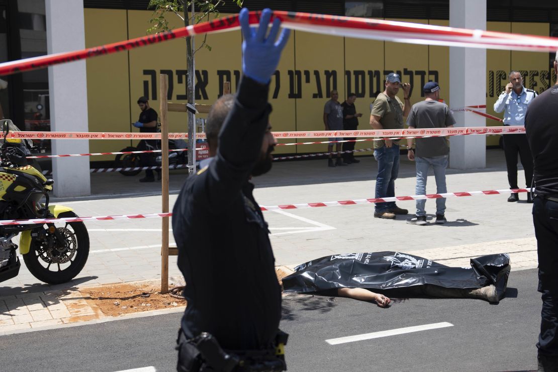 The body of the attacker is seen covered in a black plastic bag at the site of the car-ramming attack in Tel Aviv on July 4, 2023.