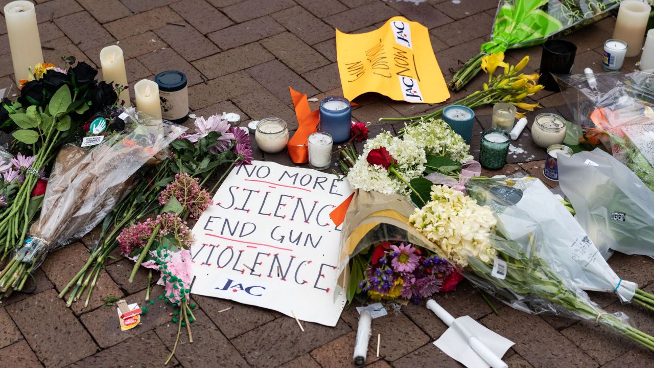 Signs and flowers are pictured at a makeshift memorial for victims of a 4th of July mass shooting in downtown Highland Park, Illinois on July 6, 2022. 