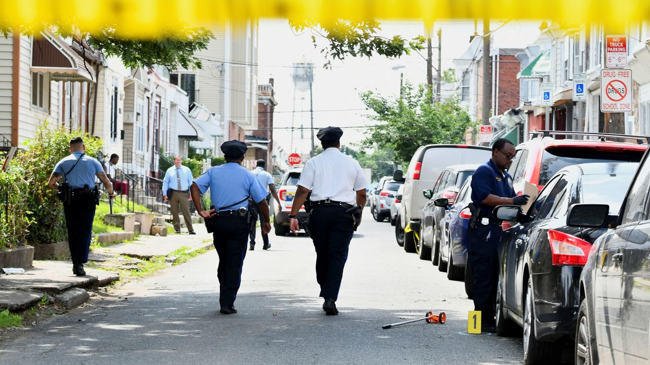 Police officers work at the scene after a mass shooting in southwest Philadelphia on Tuesday.