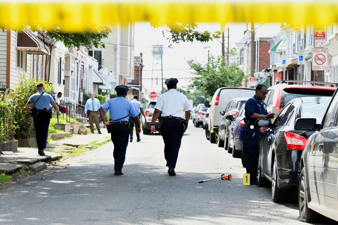 Police officers work at the scene after a mass shooting in southwest Philadelphia on Tuesday.