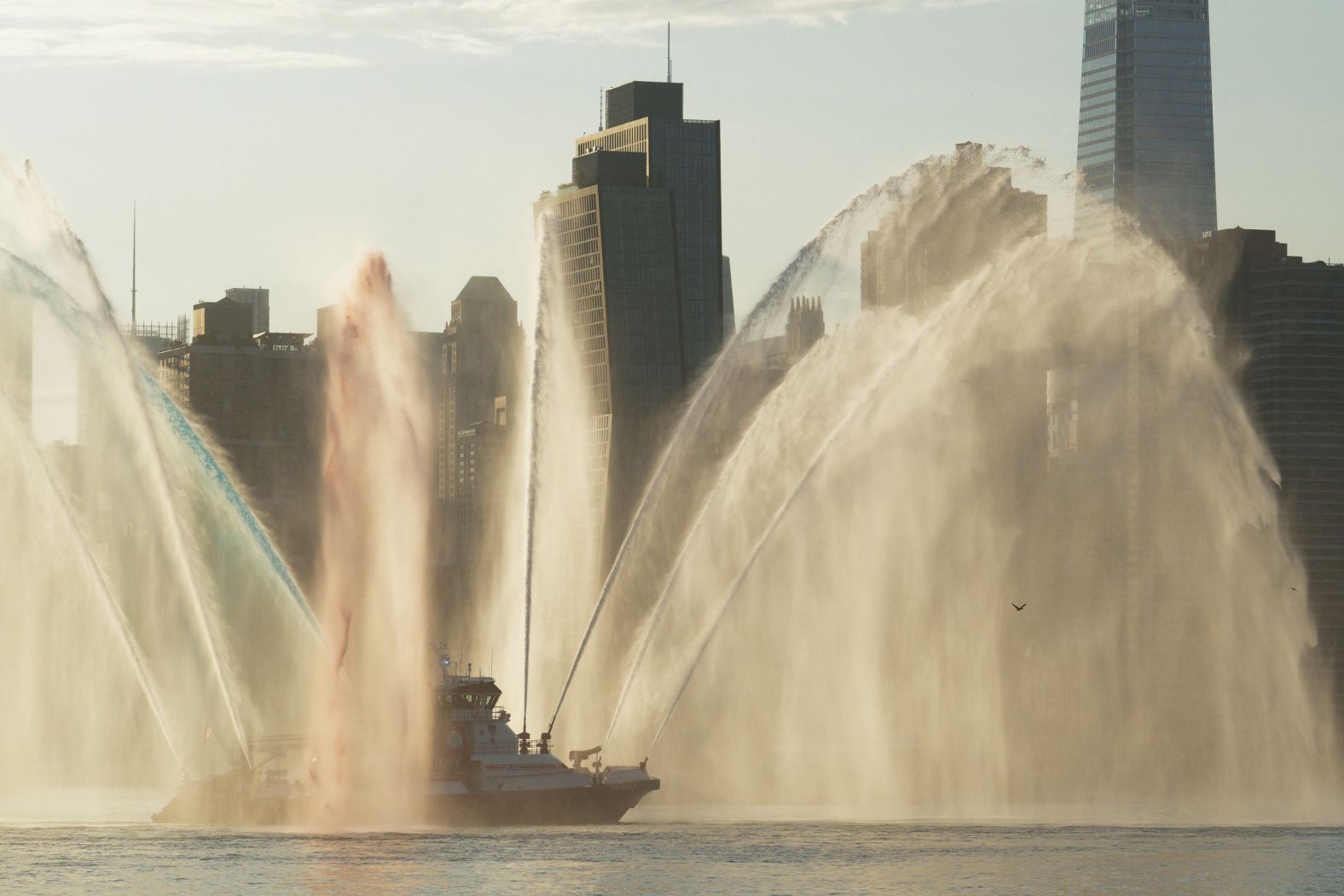 Red, white and blue water jets are propelled from a boat in New York City on Tuesday.