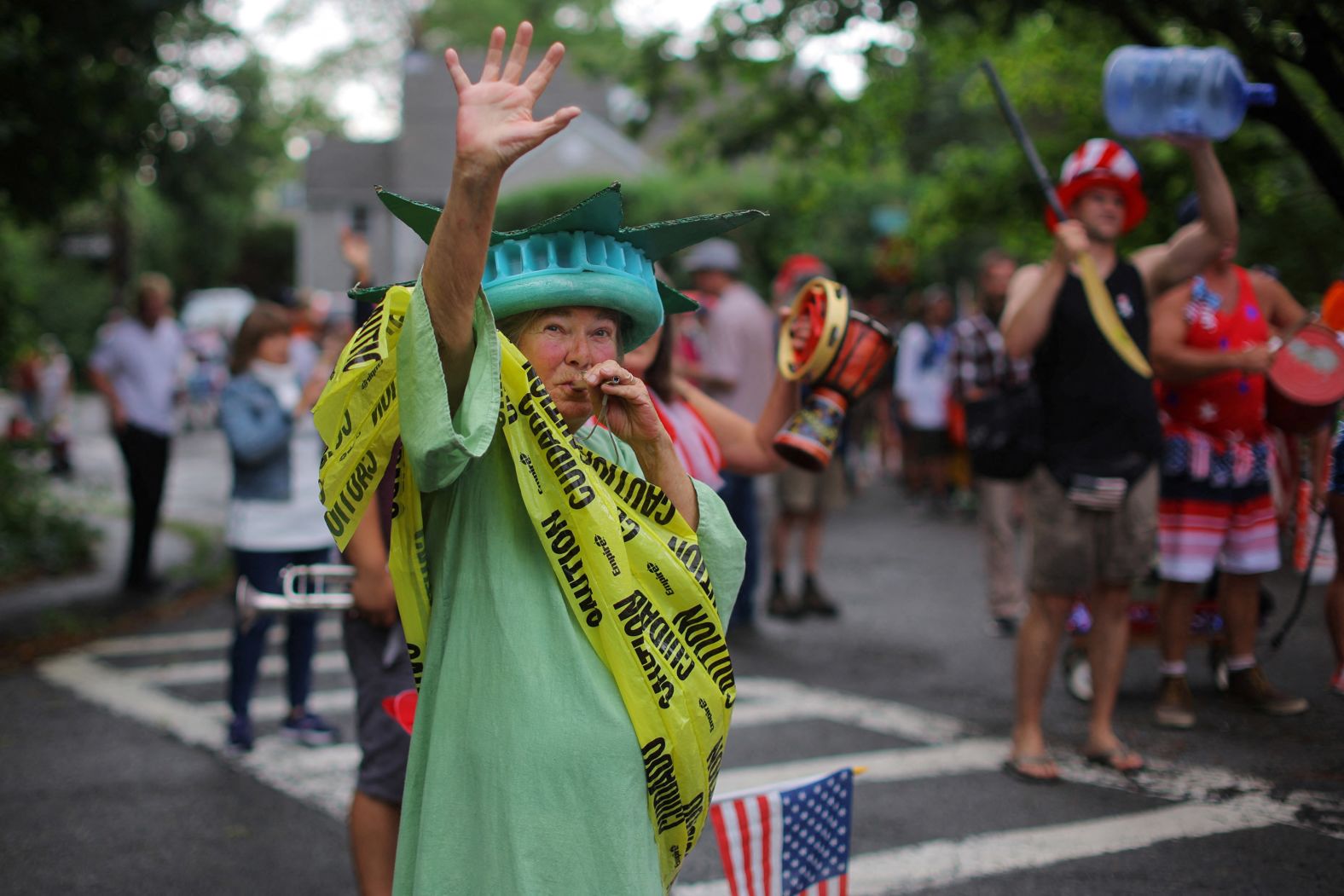 Local residents, including a woman dressed as the Statue of Liberty wrapped in caution tape, hold their own Fourth of July Parade in the Lanesville neighborhood of Gloucester, Massachusetts on Tuesday.