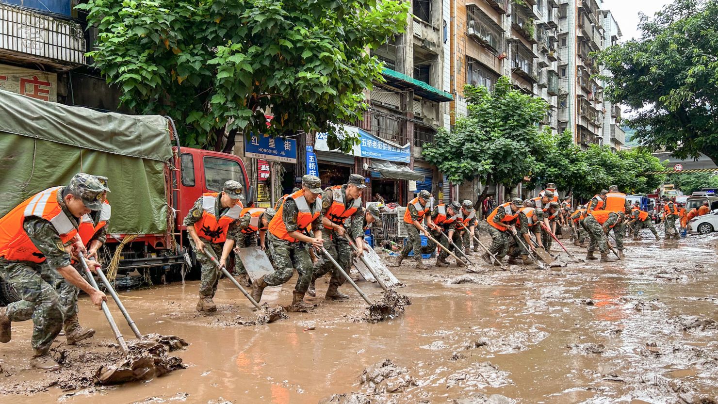 Police clean up silt in Chongqing, China, after heavy rains and floods on July 4, 2023.