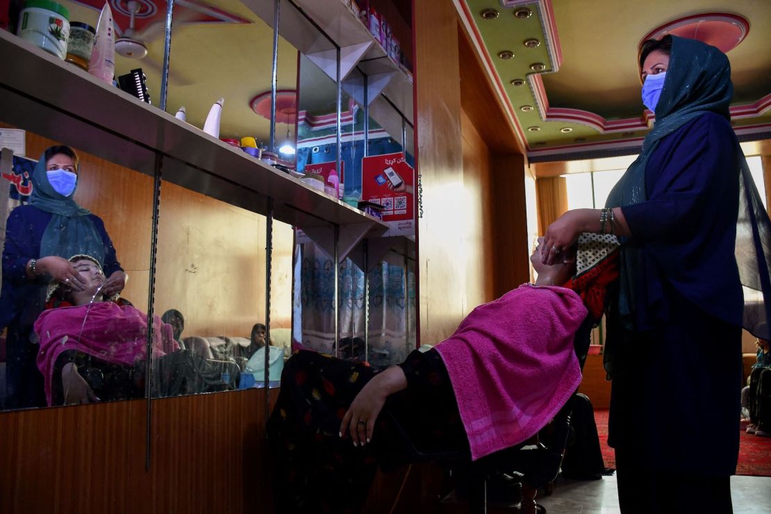 An Afghan beautician attends to a customer at a beauty salon in Mazar-i-Sharif on June 27, 2023.