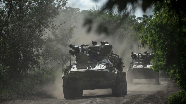 Ukrainian servicemen ride on armoured personnel carriers on a road toward Bakhmut on July 1, 2023.