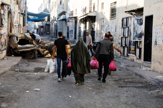 People carry their belongings on the street Wednesday after the Israeli army's withdrawal from the Jenin refugee camp.