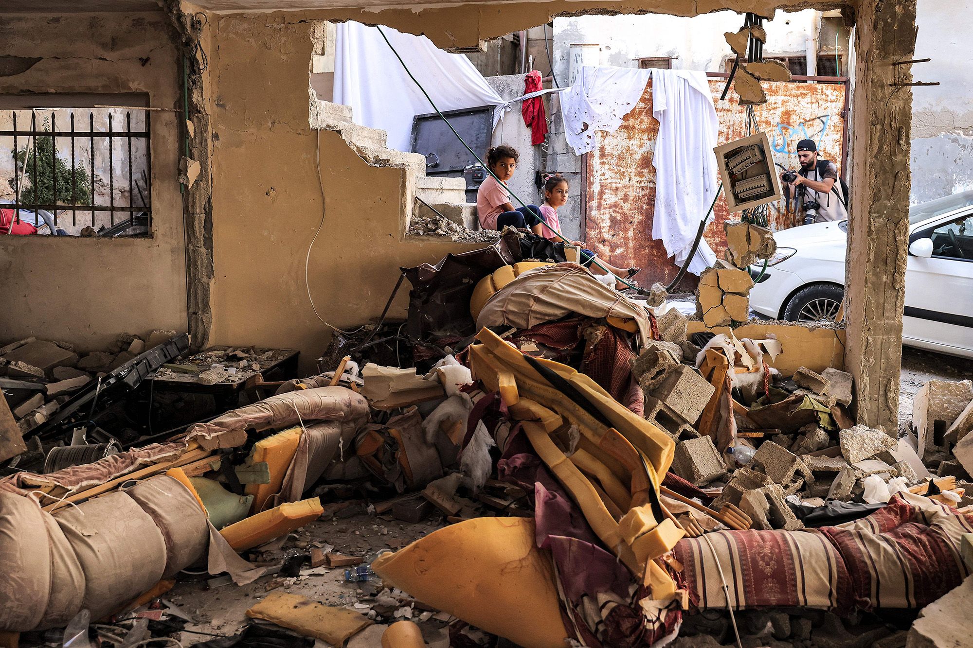 Children sit by rubble and broken furniture at a damaged building in Jenin on Wednesday.