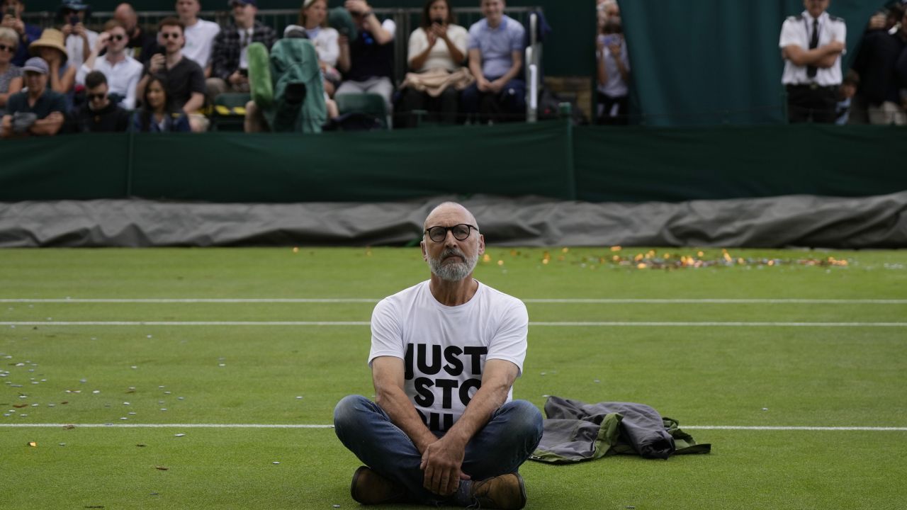 A Just Stop Oil protester sits on Court 18 on day three of the Wimbledon tennis championships in London, Wednesday, July 5, 2023. (AP Photo/Alastair Grant)
