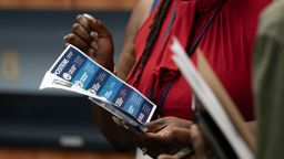 A woman holds a flyer at a career fair hosted by the New Hanover NCWorks and the Cape Fear Workforce Development Board in Wilmington, North Carolina, US, on Tuesday, June 20, 2023. 