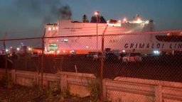 Smoke rises from a cargo ship early Thursday, July 6, 2023, in the port of Newark, New Jersey. Two firefighters were killed battling the blaze that began when cars caught fire deep inside the ship carrying 5,000 cars at the port, Newark's fire chief said. 