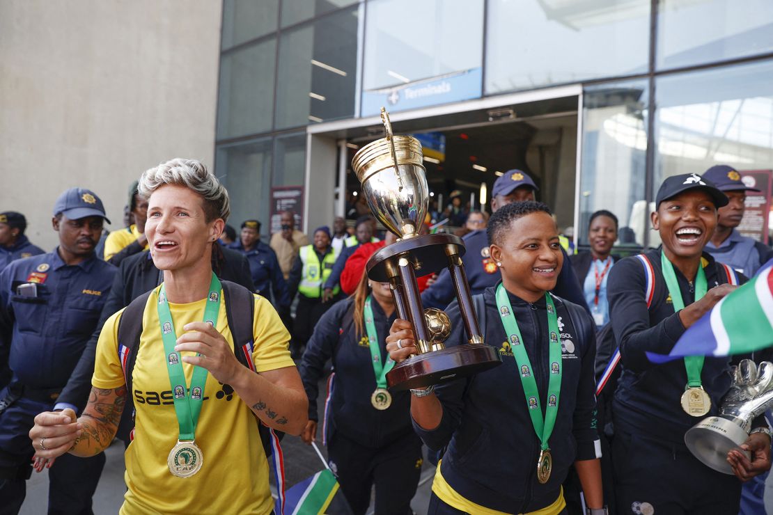 South African senior national women's team players Janine van Wyk (L), captain Refiloe Jane (C) and goalkeeper Andile Dlamini (R) react as they arrive at OR Tambo International Airport as they celebrate winning the 2022 Women's Africa Cup of Nations (WAFCON) in Kempton Park on July 26, 2022. - The team nicknamed Banyana Banyana (The Girls), won their first WAFCON on their sixth attempt after beating the host nation Morocco 2-1 at the Prince Moulay Abdellah Stadium in Rabat on Saturday, July 23. (Photo by Phill Magakoe / AFP) (Photo by PHILL MAGAKOE/AFP via Getty Images)