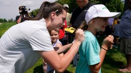 Iowa basketball player Caitlin Clark signs an autograph during the John Deere Classic golf tournament Pro-Am, Wednesday, July 5, 2023, at TPC Deere Run in Silvis, Ill. (AP Photo/Charlie Neibergall)