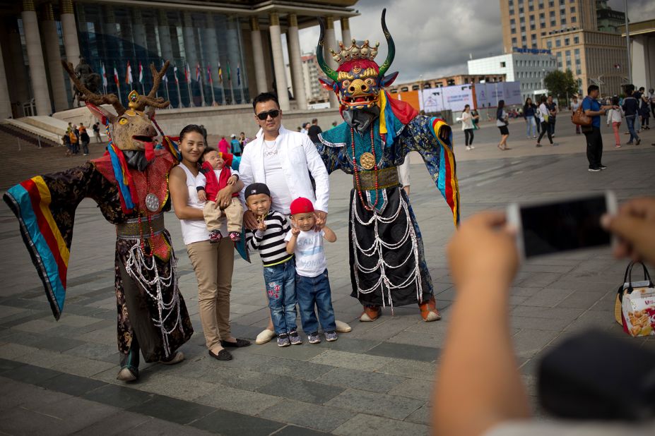 <strong>National pride: </strong>A Mongolian family poses for a photo with people dressed in traditional costumes in the capital. "During the festival, it is possible to see pride, joy and happiness on every face," says Buyandelger Ganbaatar, of tour company Nomadic Expeditions. "Naadam has become (part of) the national identity of Mongols."