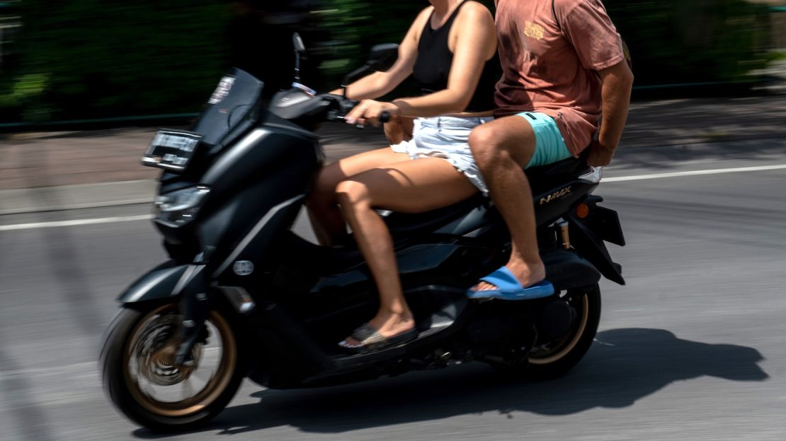 Tourists on a motorcycle, without helmets, in Canggu, Bali
