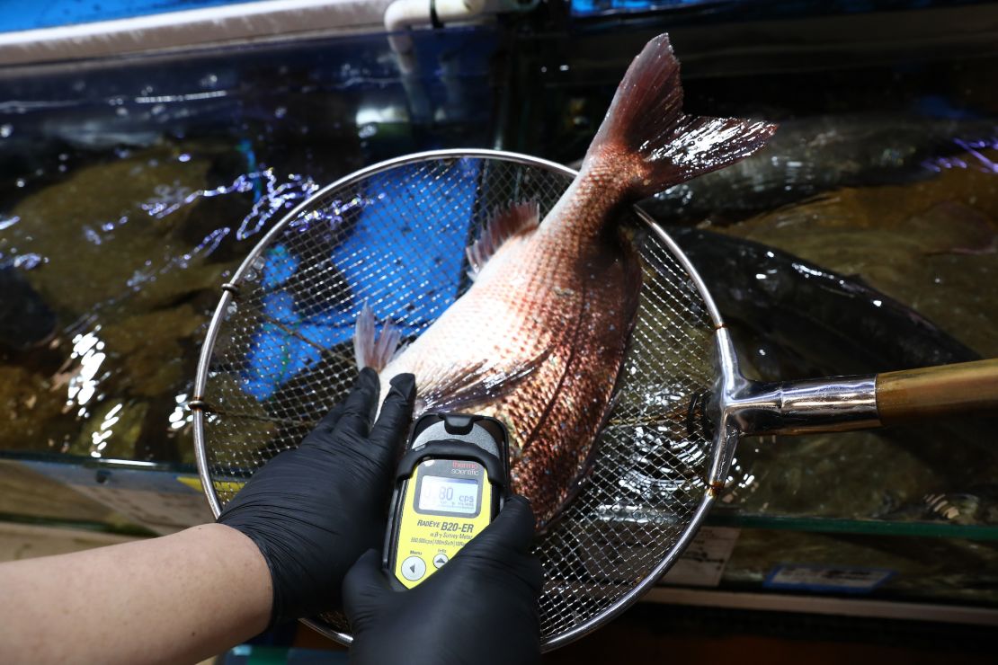 An investigator from the National Federation of Fisheries Cooperatives checks for radioactivity in sea bream from Japan at the Noryangjin fish market in Seoul on July 5, 2023. 