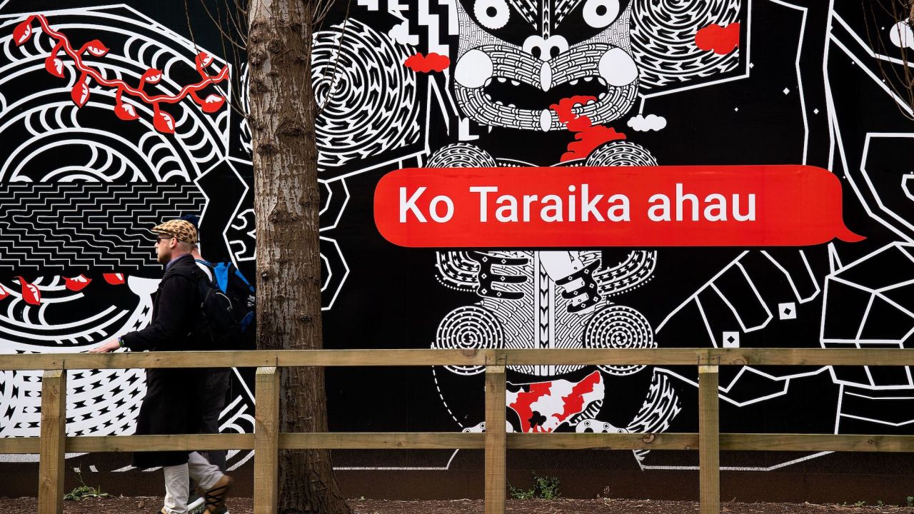 People walk past Maori language signs in Wellington, New Zealand, in 2018. 
