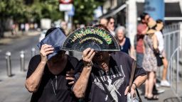 People shield themselves from the sun during high temperatures in Seville, Spain, on Thursday.