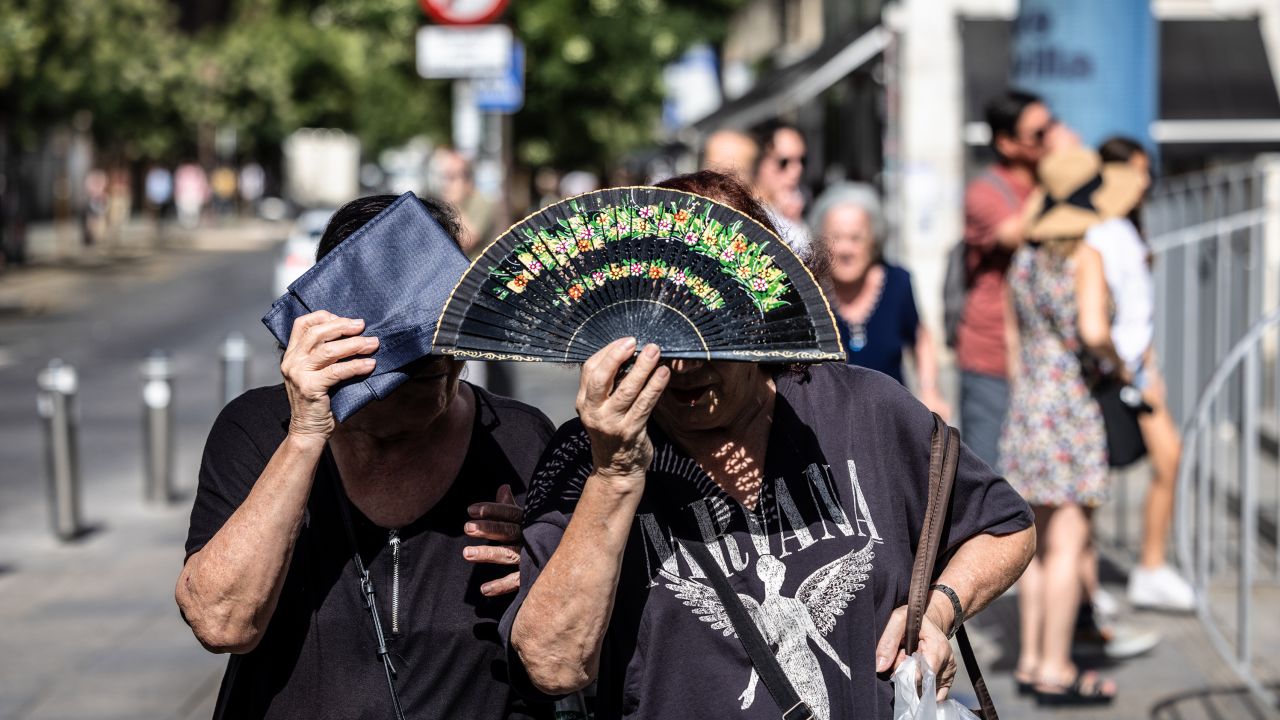 People shield themselves from the sun during high temperatures in Seville, Spain, on Thursday.