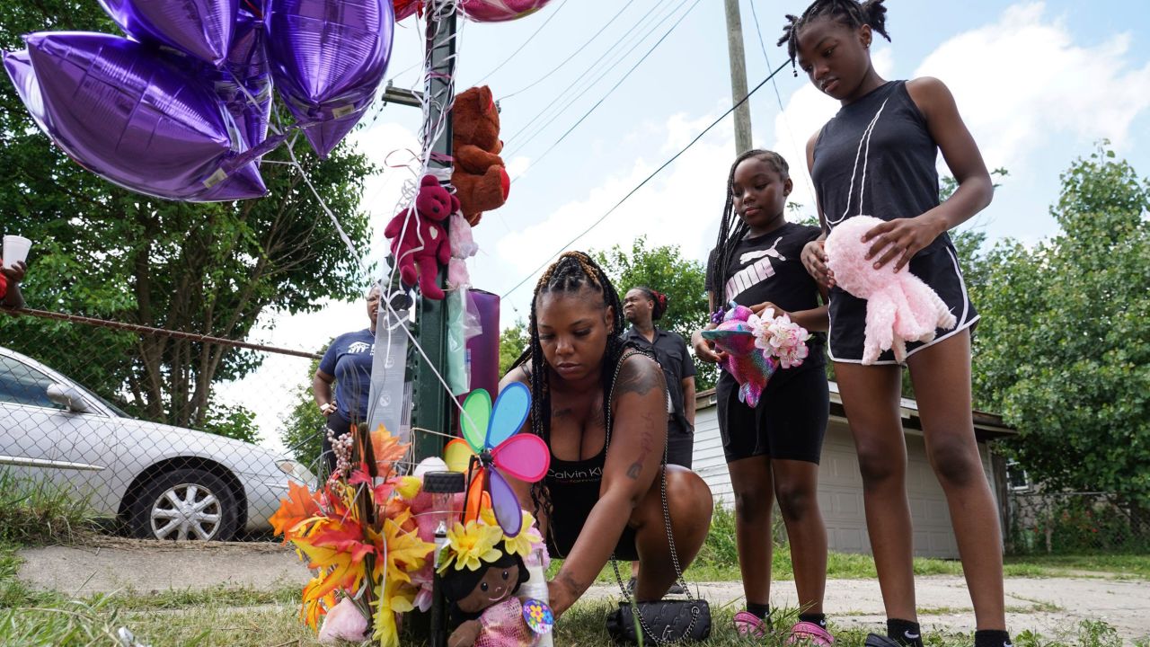 Terra Hosea of Roseville, Michigan, adds stuffed animals and balloons with her daughters Kenadi Agustas and Kanarie Hosea, right, at an impromptu memorial for Wynter Cole-Smith, 2.