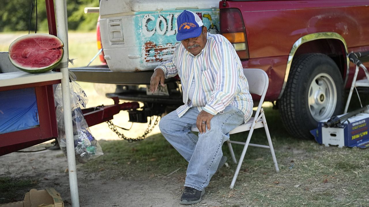 Andres Matamoros sits in the shade as he tries to keep cool while selling fresh fruit and cold coconuts Wednesday, June 28, 2023, in Houston. 