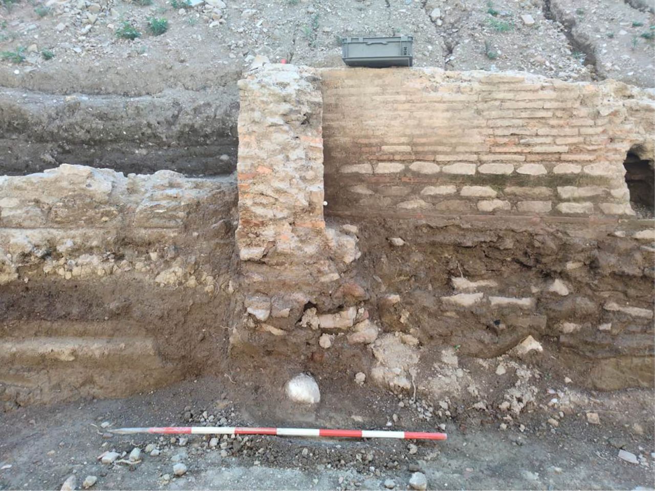 The head was found to be in the foundations of this wall.