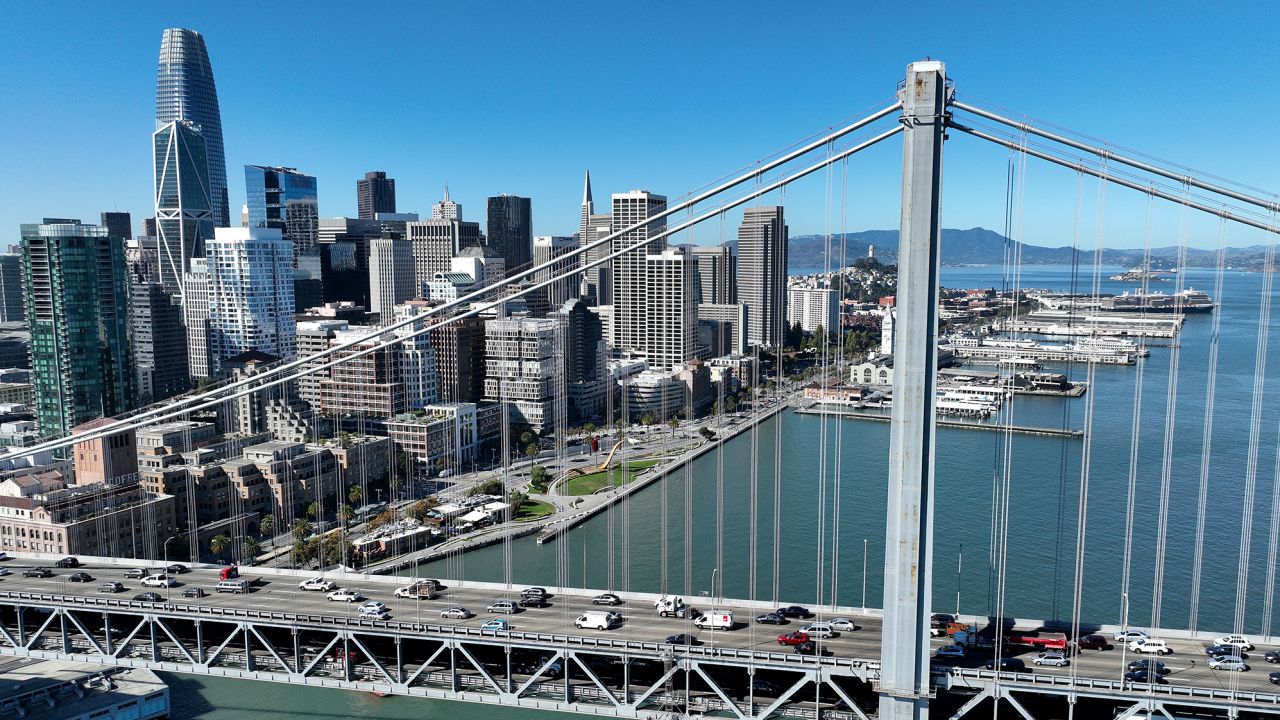 In an aerial view, cars drive by the San Francisco skyline as they cross the San Francisco-Oakland Bay Bridge on October 27, 2022 in San Francisco, California. According to a report by commercial real estate firm CBRE, the city of San Francisco has a record 27.1 million square feet of office space available as the city struggles to rebound from the Covid-19 pandemic.