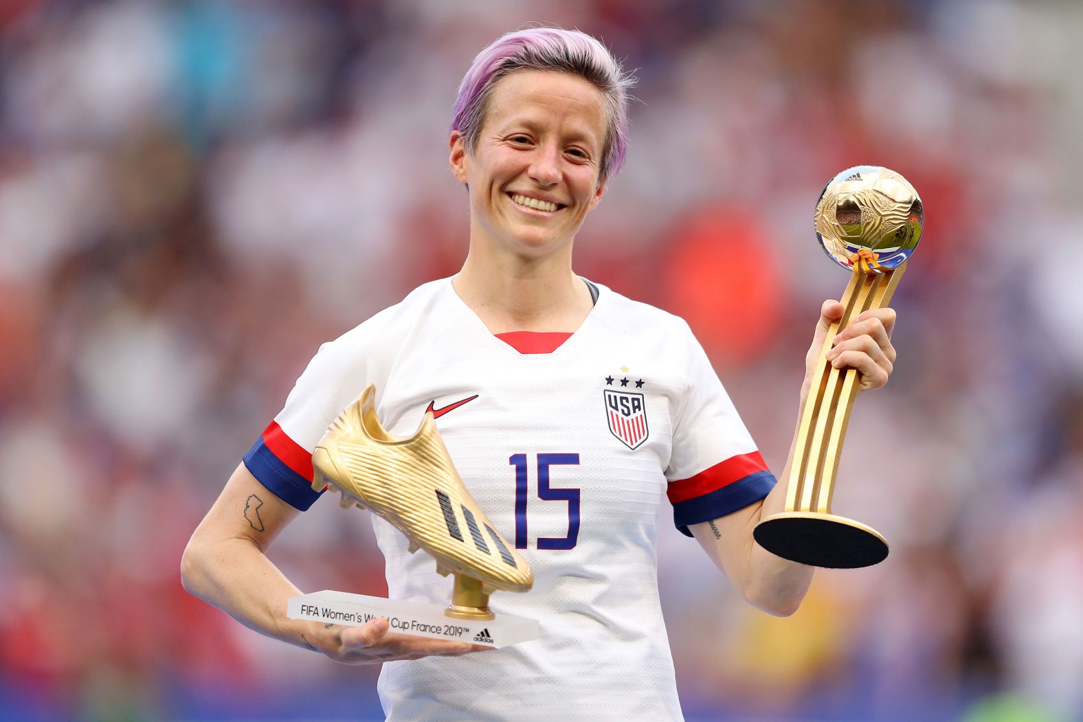 Rapinoe poses with the Golden Boot and Golden Ball awards at the 2019 World Cup. The Golden Ball is awarded to the tournament's top player and the Golden Boot is given to the tournament's top scorer.