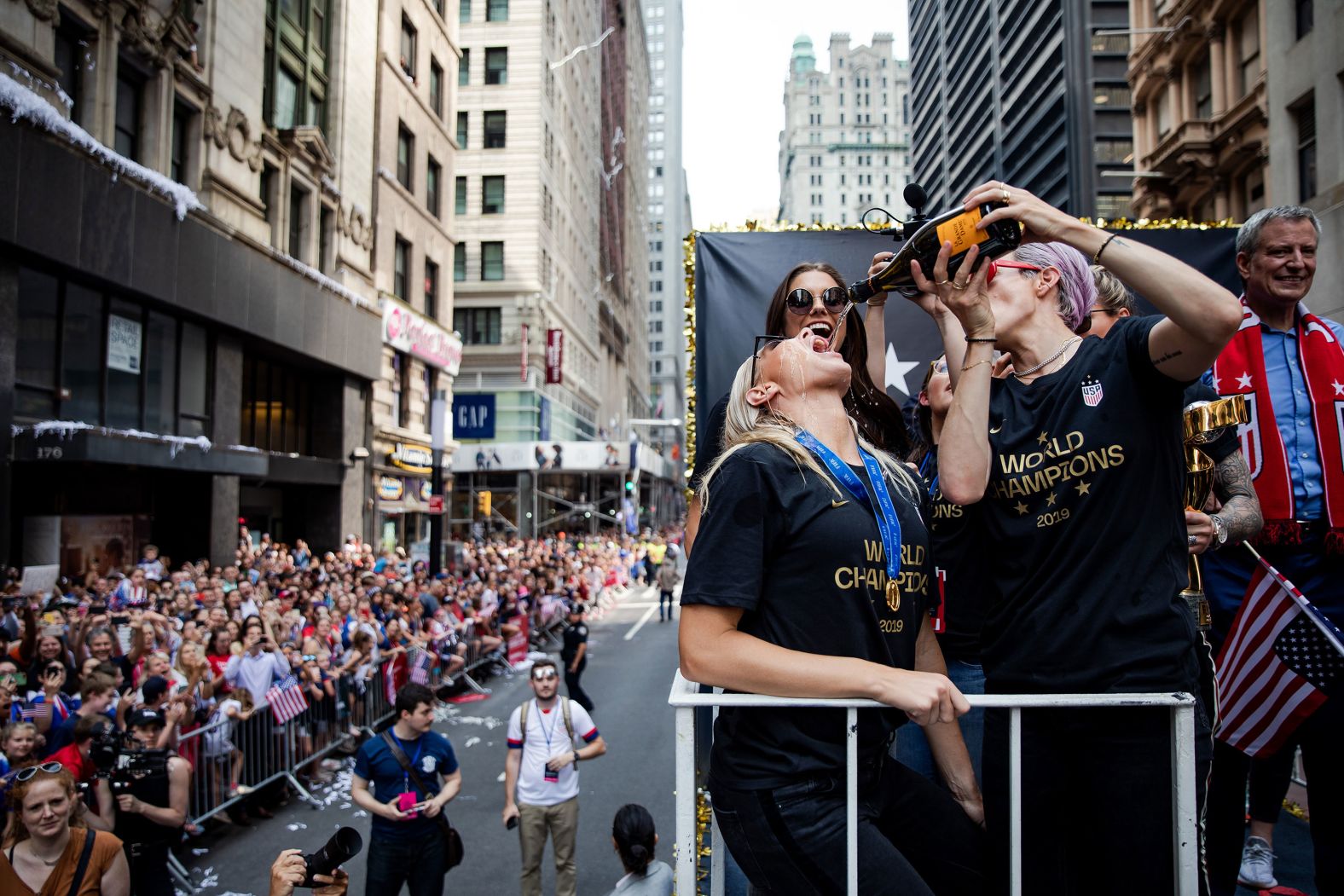 Rapinoe, right, pours champagne into Allie Long's mouth during a ticker-tape parade in New York to commemorate the Americans' World Cup victory in July 2019.
