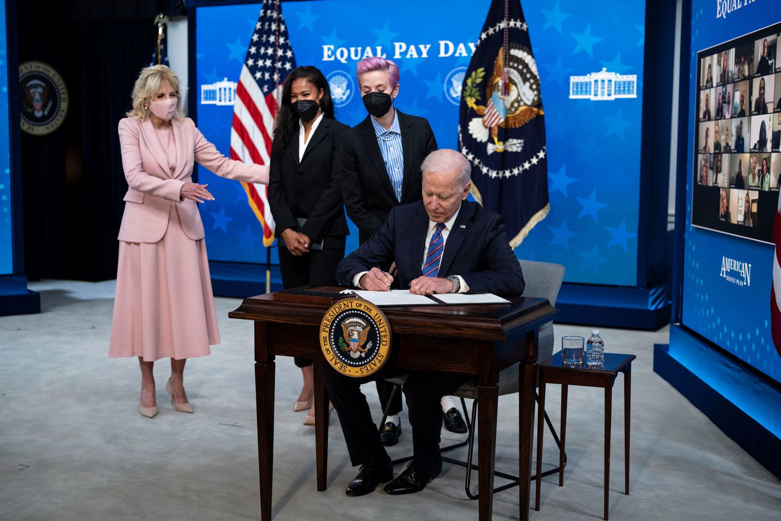From left, first lady Jill Biden, American soccer player Margaret Purce and Rapinoe watch US President Joe Biden sign a proclamation declaring March 24, 2021, as National Equal Pay Day during an event in Washington, DC.