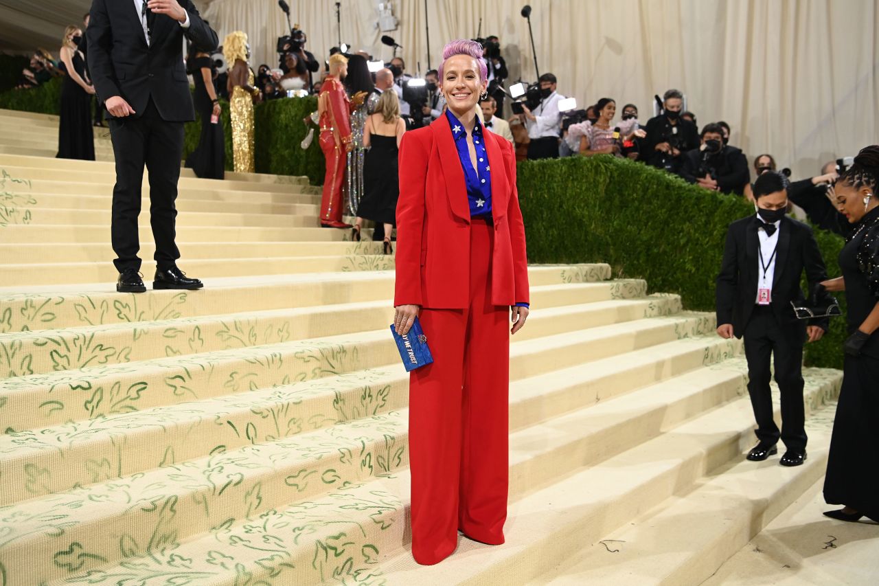 Rapinoe attends the Met Gala in September 2021. She was carrying a red, white and blue clutch that read "in gay we trust."<br />