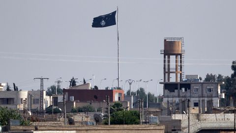An Islamic State flag flies in the northern Syrian town of Tel Abyad as it is pictured from the Turkish border town of Akcakale, in Sanliurfa province, Turkey, June 15, 2015.
