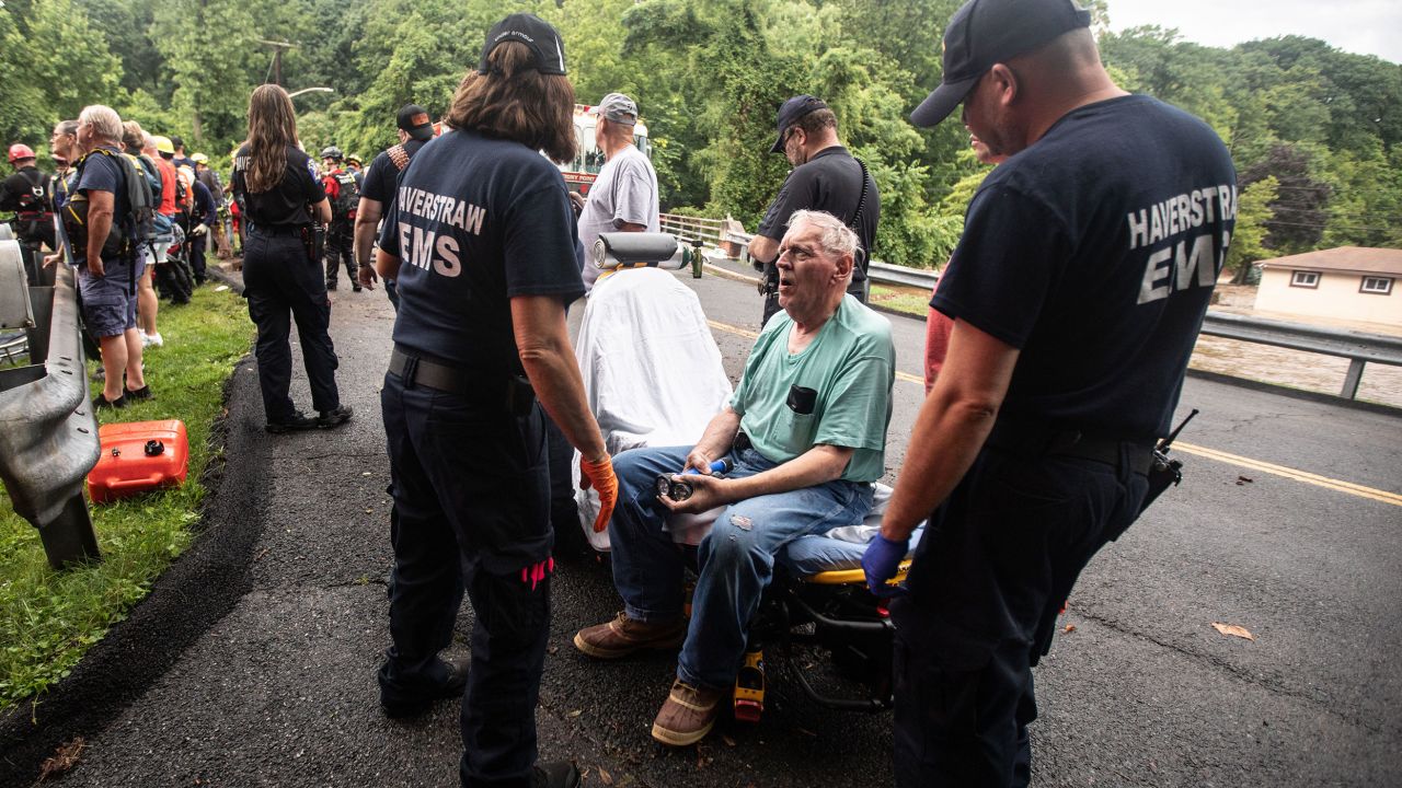 Emergency personnel tend to a resident of home in Stony Point, New York, after rescuing the man from his flooded home Sunday.