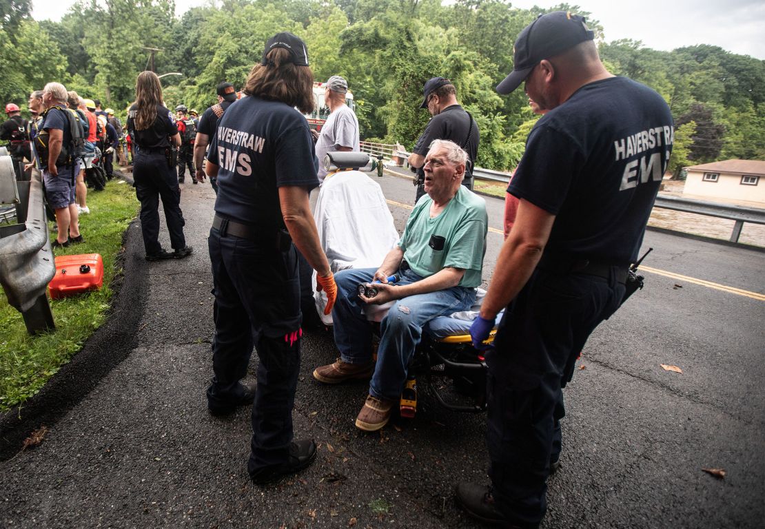 Emergency personnel tend to a resident in Stony Point, New York, after rescuing the man from his flooded home Sunday.