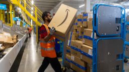 An employee places an item in to a distribution cage at the Amazon.com Inc. LCY3 fulfillment center in Dartford, UK, on Friday, July 7, 2023. Amazon launched Prime Day in 2015 to attract new subscribers who now pay $139 a year for shipping discounts, video streaming and other perks. 