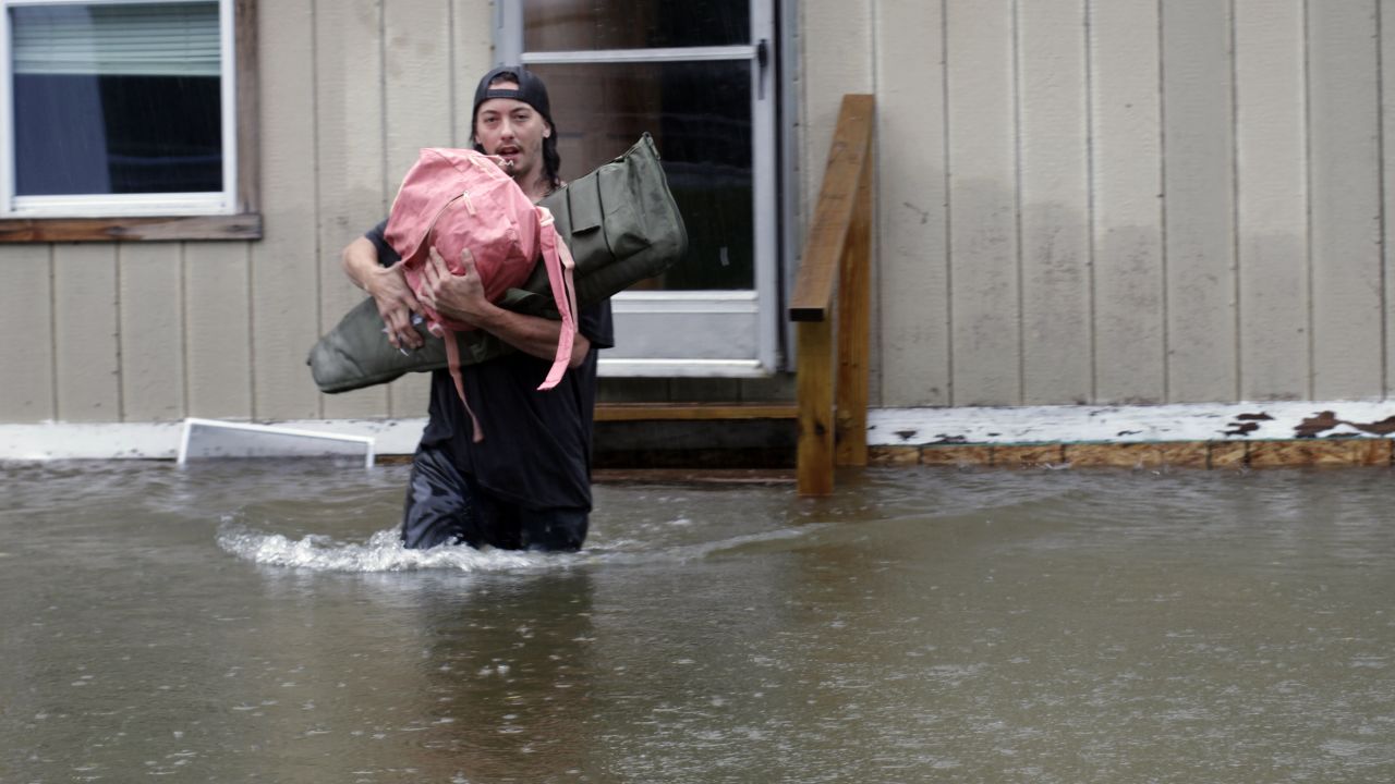 A man carries belongings through floodwaters from a home in Bridgewater, Vermont, on Monday.