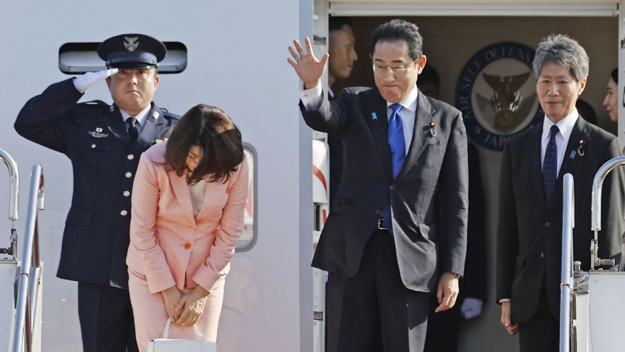 Japanese Prime Minister Fumio Kishida waves before departing on a government plane on July 11, 2023, for the NATO summit.