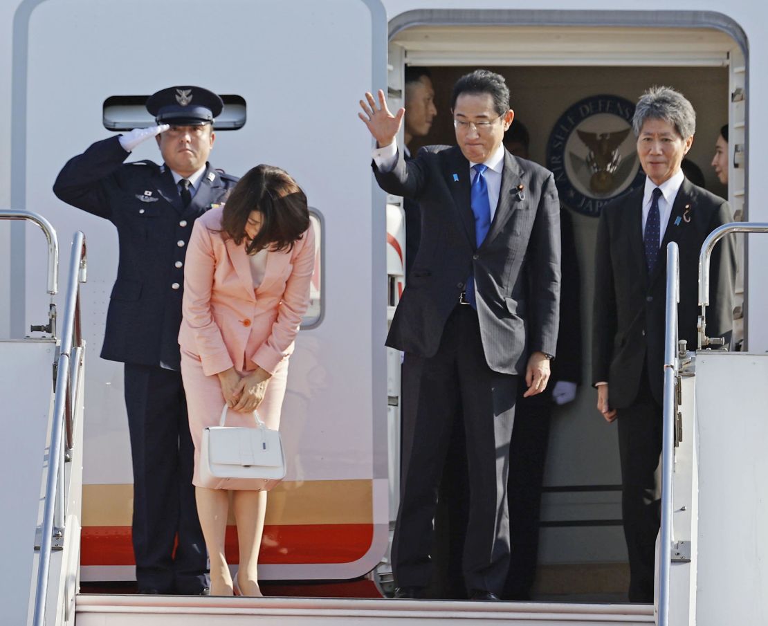 Japanese Prime Minister Fumio Kishida waves before departing on a government plane on July 11, 2023, for the NATO summit.
