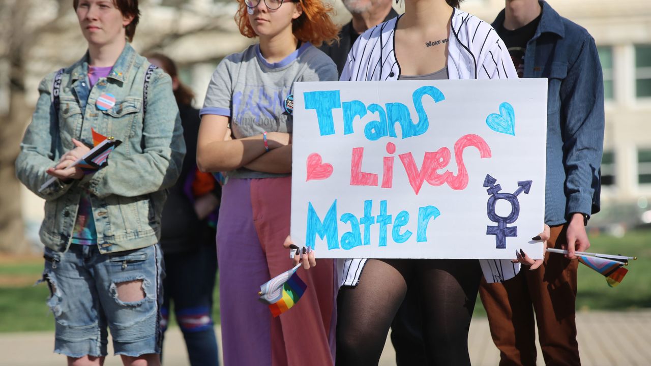 A demonstrator listens to speakers at a rally held in support of transgender youth in Kansas. It comes amid a raft of anti-transgender legislation in the Sunflower State.