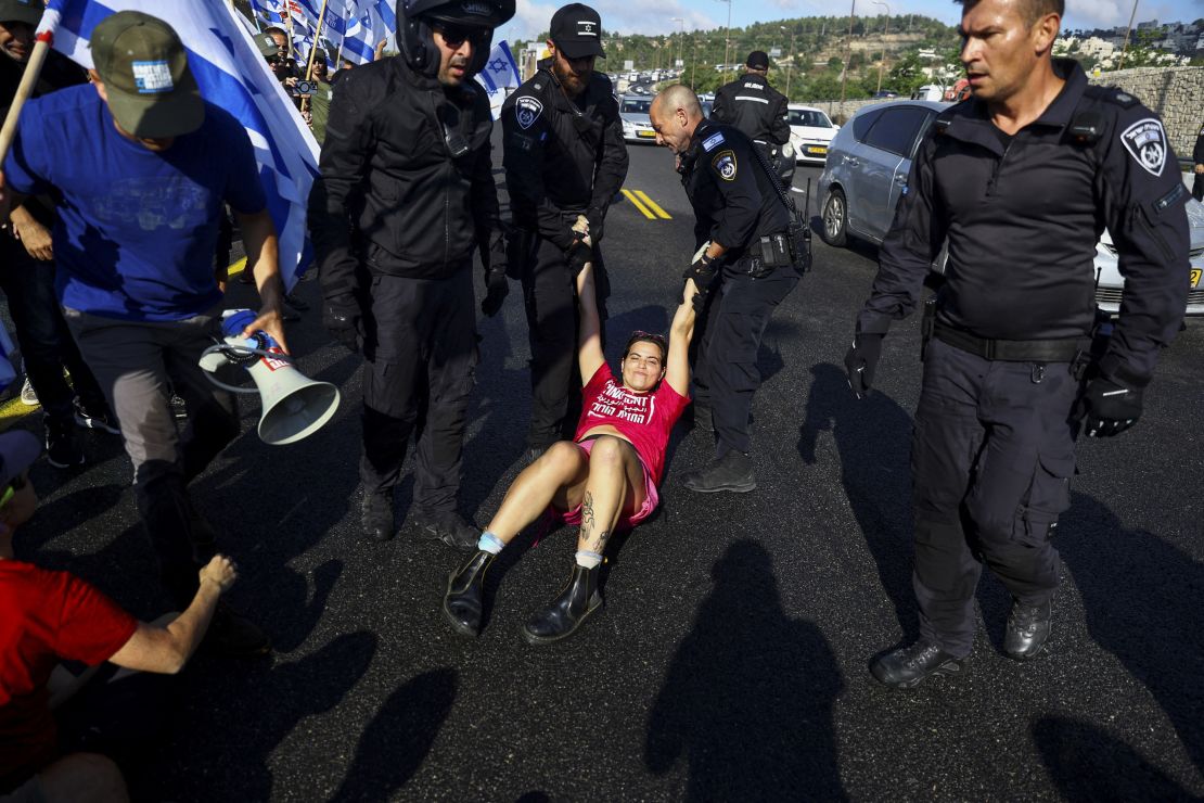 Members of the security forces remove a demonstrator blocking a highway to Jerusalem.