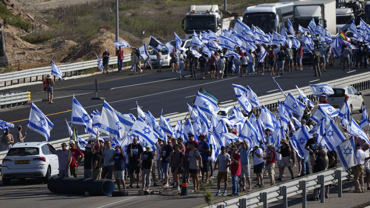 Protesters waving Israeli flags block a highway near Beit Yanai.