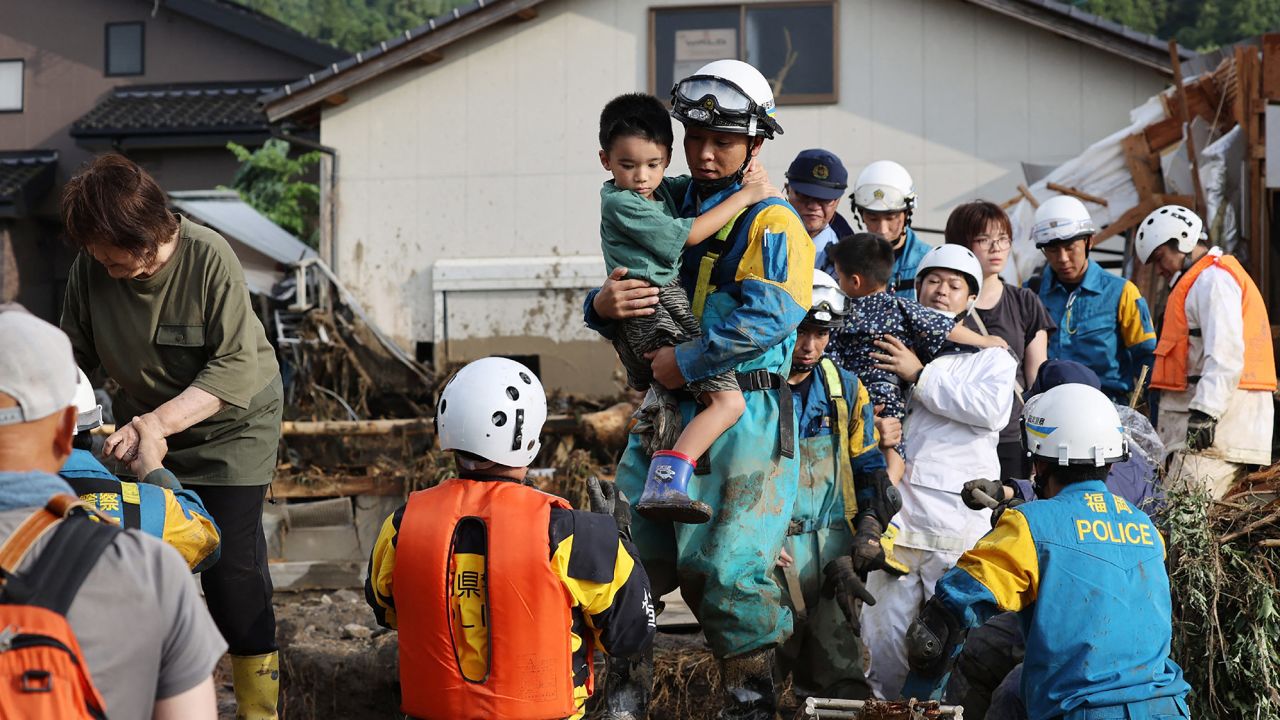 Residents are rescued following a flood in their street in Tanushimarumachi in the city of Kurume, Fukuoka prefecture, on July 10, 2023.