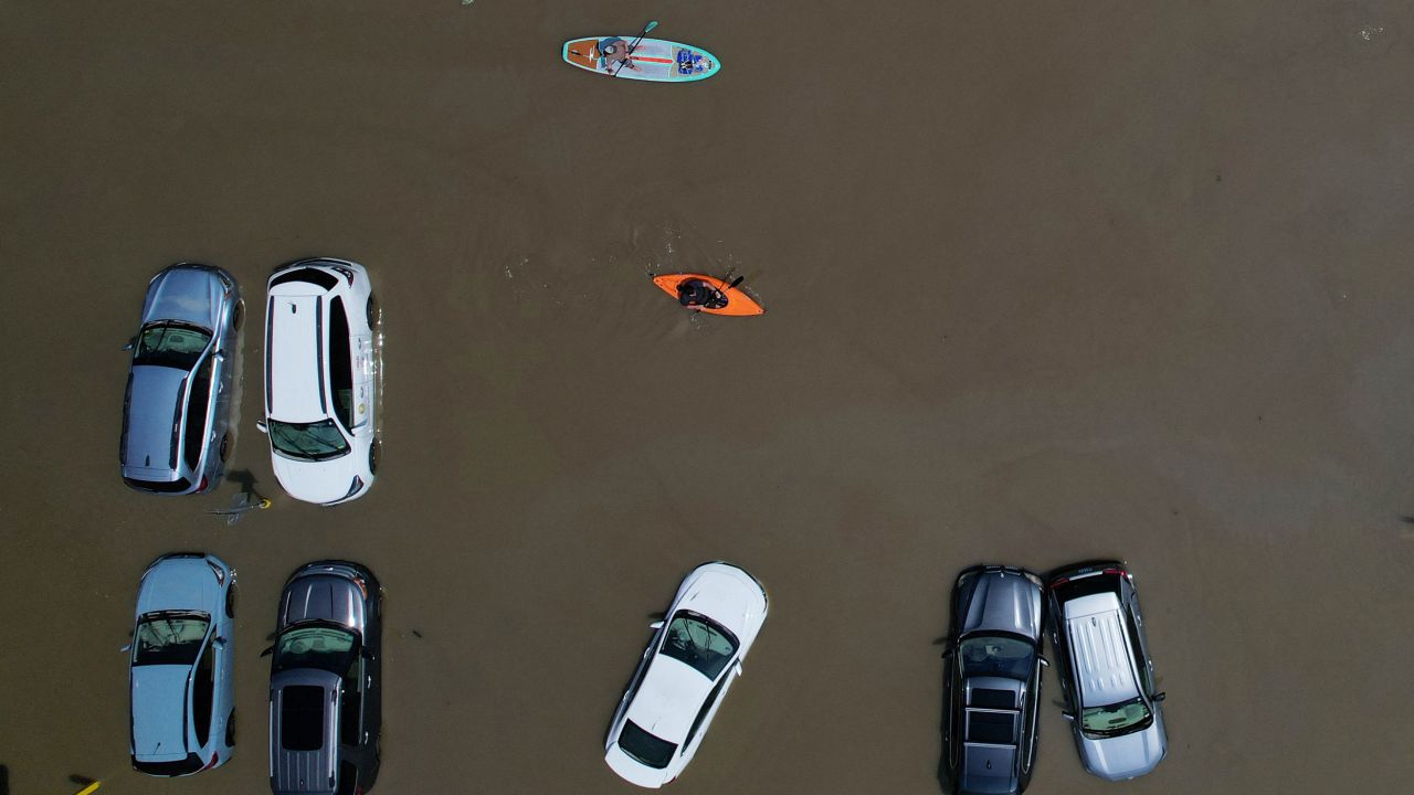 People paddle past partially submerged cars in Montpelier, Vermont, on Tuesday.
