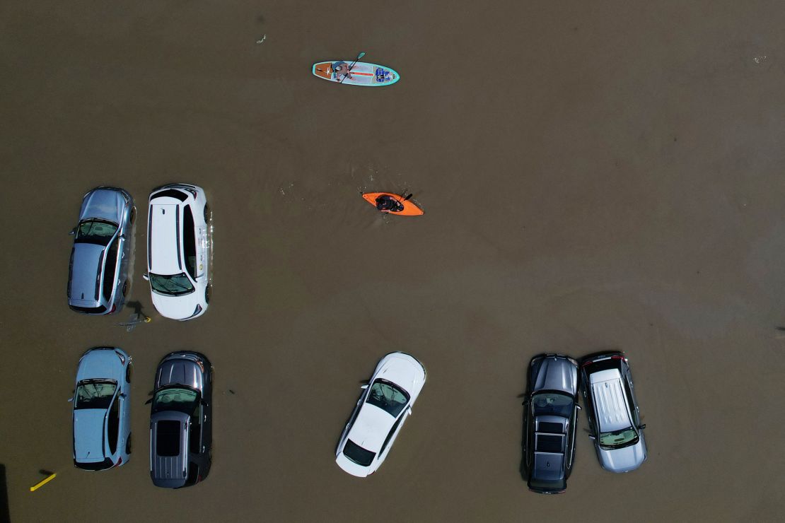 Residents paddle past partially submerged cars Tuesday in Montpelier, Vermont.