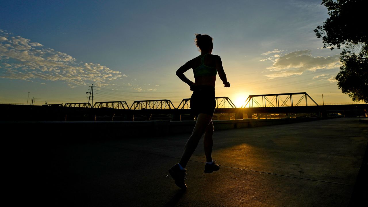 A runner jogs at sunrise, on Wednesday, July 12, 2023 in Tempe, Ariz. Even desert residents accustomed to scorching summers are feeling the grip of an extreme heat wave smacking the Southwest this week. 