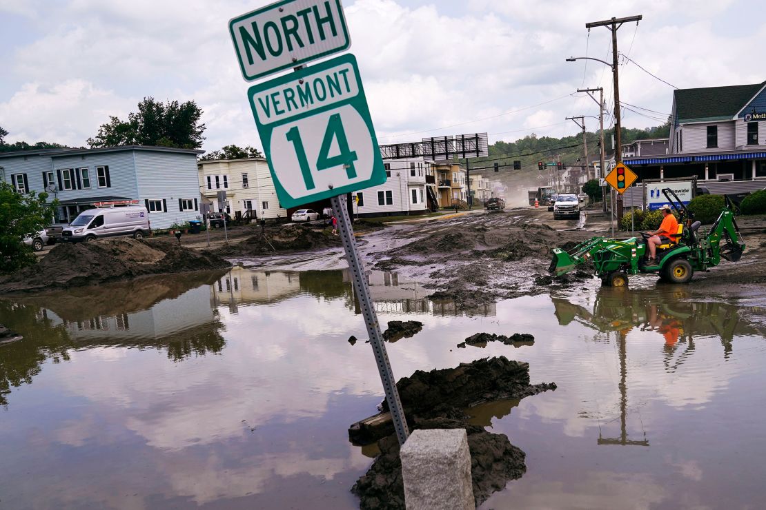A tractor clears water from a business Wednesday in Barre, Vermont, after a storm dumped almost two months of rain in two days. 
