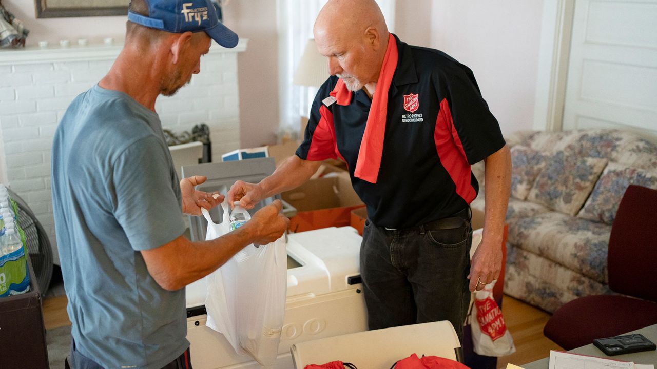A volunteer distributes cold water at the emergency heat aid station at the Salvation Army's Phoenix Citadel Corps on July 12, 2023, in Phoenix, Arizona.