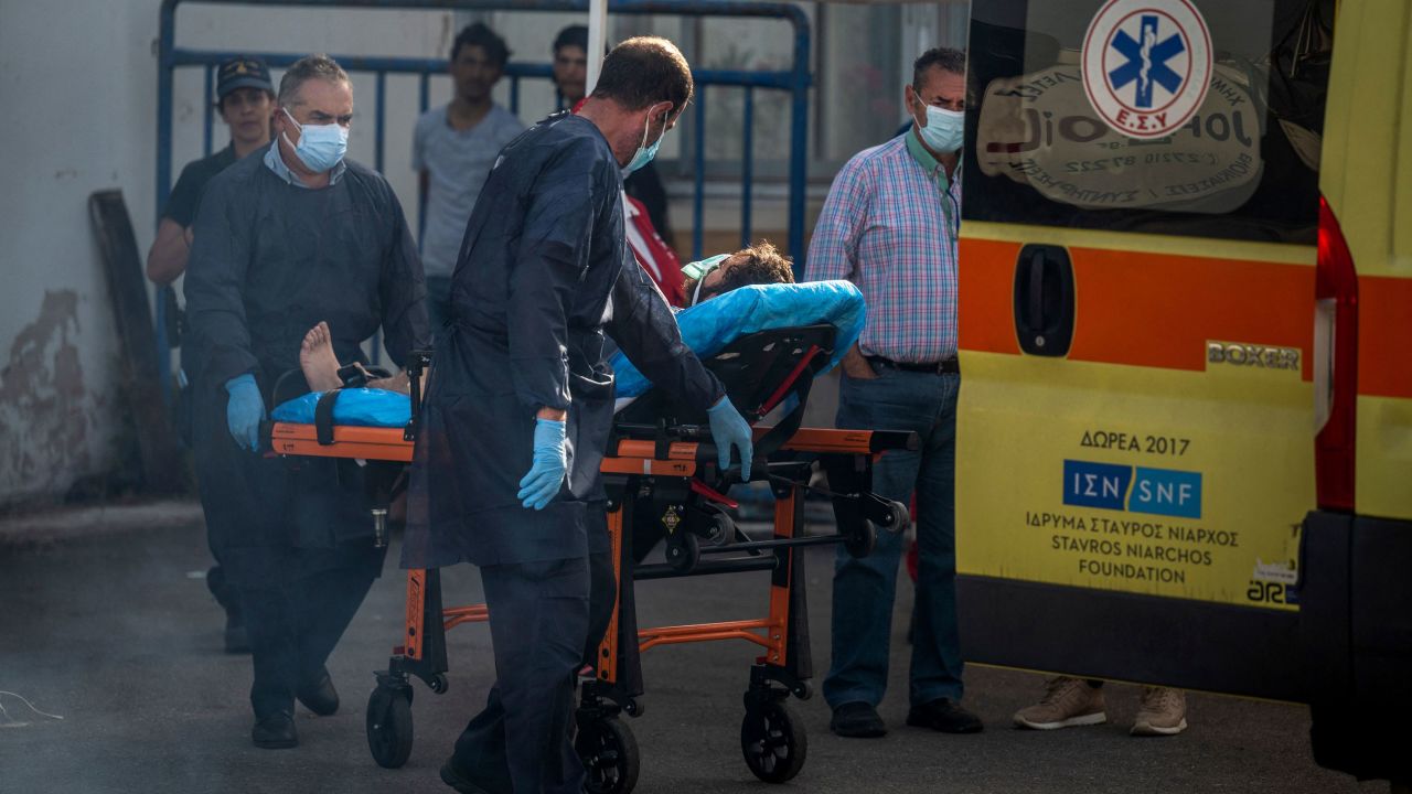 Medical staff carry a survivor on a stretcher outside a warehouse at the port in Kalamata town, on June 15.